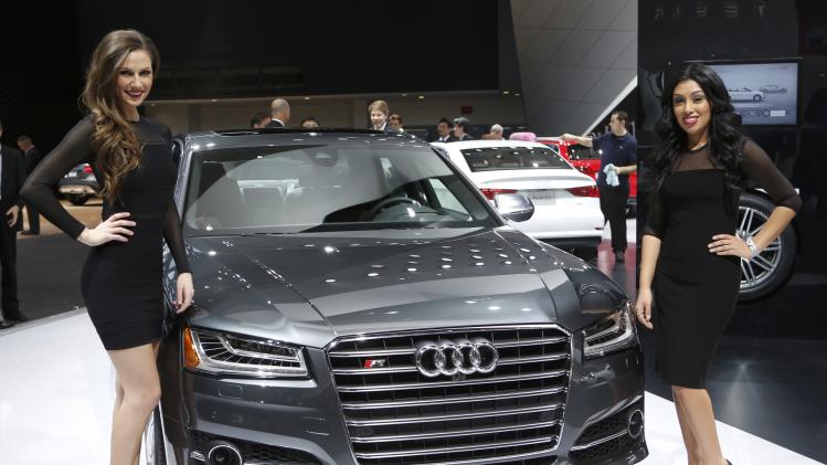 Models pose next to a 2014 Audi S8 during the press preview day of the North American International Auto Show in Detroit
