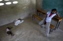 In this Thursday, June 18, 2015 photo, Milene Monime, 16, sits as her two-month-old son Jefferson Thezon, center, sleeps next to another person's child inside a school classroom where her family and others are staying after being deported the previous day from neighboring Dominican Republic, in the village of Fonbaya, Haiti. People began preparing Thursday for deportation from the Dominican Republic after failing to obtain legal residency as part of a government program to crack down on migrants, most of them from neighboring Haiti or of Haitian descent. (AP Photo/Rebecca Blackwell)