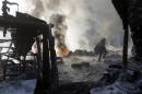 AP10thingsToSee - A protester walks past burning tires following clashes with police in central Kiev, Ukraine on Saturday, Jan. 25, 2014. (AP Photo/Darko Vojinovic, File)