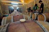 Workers fill wine barrels at the Red Mountain estate near Inle Lake in Myanmar's eastern Shan State on August 4, 2012. The vineyard, which produces roughly 120,000 bottles a year, has itself become a draw for foreigners intrigued that vines could grow in the tropical country