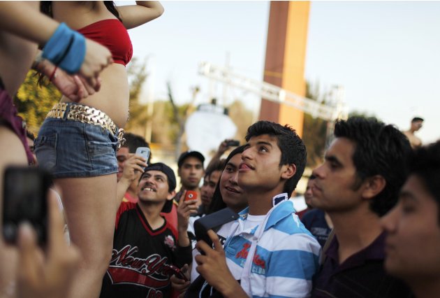 Visitors look at dancers perform at the Sex and Entertainment 2012 adult exhibition at the Palacio de los Deportes in Mexico City