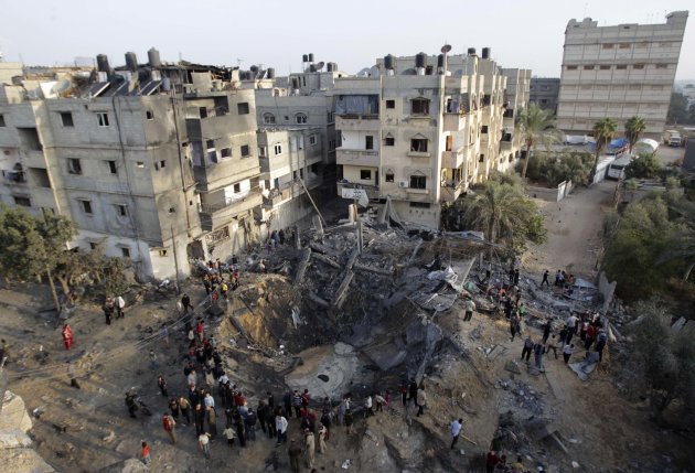 Palestinians gather around a destroyed house after an Israeli air strike in Khan Younis in the southern Gaza Strip