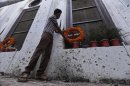Un hombre cristiano paquistaní coloca flores en el lugar en el que se produjo un atentado, en una iglesia de Pesháwar, Pakistán, el pasado 24 de septiembre. EFE