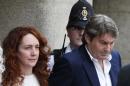 Rebekah Brooks, former News International chief executive, left, accompanied by her husband Charlie Brooks, leaves the Central Criminal Court in London, Tuesday, June 24, 2014. Former News of the World editor Andy Coulson was convicted of phone hacking Tuesday, but fellow editor Rebekah Brooks was acquitted after a months-long trial centering on illegal activity at the heart of Rupert Murdoch's newspaper empire. A jury at London's Old Bailey unanimously found Coulson, the former spin doctor of British Prime Minister David Cameron, guilty of conspiring to intercept communications. Brooks was acquitted of that charge and of counts of bribing officials and obstructing police. The nearly eight-month trial was triggered by revelations that for years the News of the World used illegal eavesdropping to get stories, listening in on the voicemails of celebrities, politicians and even crime victims. (AP Photo/Lefteris Pitarakis)