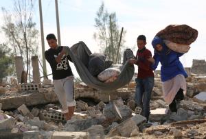 Syrians collect items from their destroyed house in &hellip;