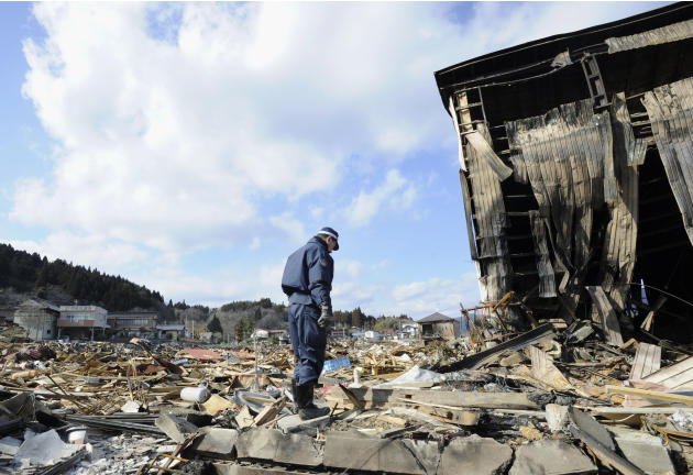 A police officer stands in silence among the debris at the destructed city of Kesennuma, northeastern Japan, Friday, March 18, 2011, just one week after the devastative earthquake and resulting tsunam