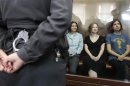 Members of the female punk band "Pussy Riot" (R-L) Nadezhda Tolokonnikova, Maria Alyokhina and Yekaterina Samutsevich sit in a glass-walled cage during a court hearing in Moscow, August 17, 2012.