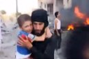 In this image taken from video obtained from the Shaam News Network, which has been authenticated based on its contents and other AP reporting, a Syrian man carries an injured child away from a missile strike in Raqqa, Syria, Wednesday, Aug. 7, 2013. Wednesday's missile attack came after Human Rights Watch said missiles fired by the Syrian army into populated areas have killed hundreds of civilians in recent months. (AP Photo/Shaam News Network via AP video)