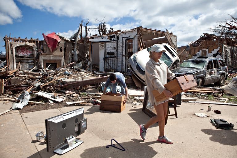 In the aftermath of a severe tornado, Kelly Giddens (R) helps University of Alabama law student Daniel Hinton remove belongings from his destroyed home in the Cedar Crest neighborhood in Tuscaloosa, Alabama. Shocked Americans struggled Thursday to grasp the magnitude of the worst US tornadoes in decades, which carved a trail of destruction across the south, leaving 280 people dead