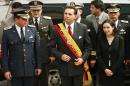 FILE - In this Jan. 15, 2000 file photo, Ecuador's President Jamil Mahuad, center, his daughter Paola Mahuad, right, and military officials arrive to Congress in Quito, Ecuador. Ecuadorean authorities announced on Tuesday, May 27, 2014 via Twitter that an arrest warrant has been issued for former President Jamil Mahuad for allegedly misappropriating public funds during the country's late 1990s banking crisis. Mahuad fled a 2000 coup and settled in the United States. (AP Photo/Silvia Izquierdo, File)