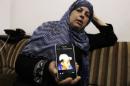 Suha, mother of Mohammed Abu Khudair, shows a picture of her son on her mobile phone at their home in Shuafat
