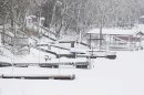 Snow covers docks the no longer reach the low water of Lakeview, a private lake and club, near Lawrence, Kan., Tuesday, Feb. 26, 2013. For the second time in a week, a major winter storm paralyzed parts of the nation's midsection Tuesday, dumping a fresh layer of heavy, wet snow atop cities still choked with piles from the previous system and making travel perilous from the Oklahoma panhandle to the Great Lakes. The weight of the snow strained power lines and cut electricity to more than 100,000 homes and businesses. At least three deaths were blamed on the blizzard. (AP Photo/Orlin Wagner)