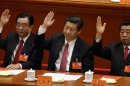 Chinese vice President Xi Jinping, center, Central Commission for Discipline Inspection head He Guoqiang, left, and Chinese People's Political Consultative Conference Chairman Jia Qinglin raise their hands to show approval for a work report during the closing ceremony for the 18th Communist Party Congress held at the Great Hall of the People in Beijing, China, Wednesday Nov. 14, 2012. (AP Photo/Lee Jin-man)