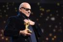 Italian director Gianfranco Rosi reacts after receiving the Golden Bear for Best Film for the film "Fuocoammare (Fire at Sea)" on February 20, 2016 in Berlin