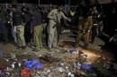 Security officials gather at the site of a blast outside a public park in Lahore