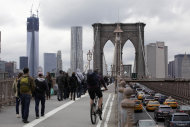 Commuters cross New York's Brooklyn Bridge, Wednesday, Oct. 31, 2012. The floodwaters that poured into New York's deepest subway tunnels may pose the biggest obstacle to the city's recovery from the worst natural disaster in the transit system's 108-year history. (AP Photo/Richard Drew)