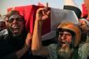 Supporters of Egypt's ousted President Mohammed Morsi chant angry slogans as they carry a coffin covered with the national flag, of a man killed after Egyptian troops opened fire on mostly Islamist protesters marching on a Republican Guard headquarters Friday, in Cairo, Saturday, July 6, 2013. (AP Photo/Khalil Hamra)