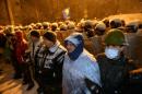 Pro-EU protesters stand in front of riot policemen outside the presidential office in Kiev on December 9, 2013