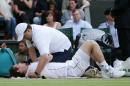 Andy Murray of Britain receives medical treatment on his shoulder during the singles match against Andreas Seppi of Italy at the All England Lawn Tennis Championships in Wimbledon, London, Saturday July 4, 2015. (AP Photo/Tim Ireland)