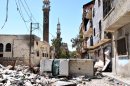 In this Friday, April 20, 2012 photo, a damaged car from Syrian government forces shelling is seen on a street in Homs, Syria. (AP Photo)