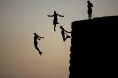 FILE -In this Tuesday, Aug. 2, 2016 file photo, Israeli Arab boys jump into the Mediterranean sea from the ancient wall surrounding the old city of Acre, northern Israel. (AP Photo/Ariel Schalit, File)