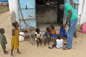 Mamadou Ka greets children near his family home after being repatriated last month from Gabon, in Dakar