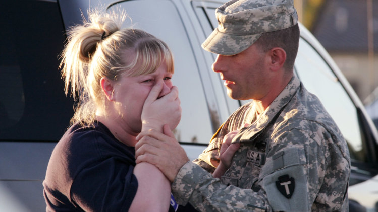 FILE- In this Nov. 5, 2009, file photo, Sgt. Anthony Sills, right, comforts his wife as they wait outside the Fort Hood, Texas, army base where their young son was in daycare. Nidal Hasan is charged in the 2009 shooting rampage at Fort Hood that left 13 dead and more than 30 others wounded. Hasan doesn’t deny that he carried out the rampage, but military law prohibits him from entering a guilty plea because authorities are seeking the death penalty. If he is convicted and sentenced to death in a trial that starts Tuesday, Aug. 6, 2013, there are likely years, if not decades, of appeals ahead. (AP Photo/Jack Plunkett, File)