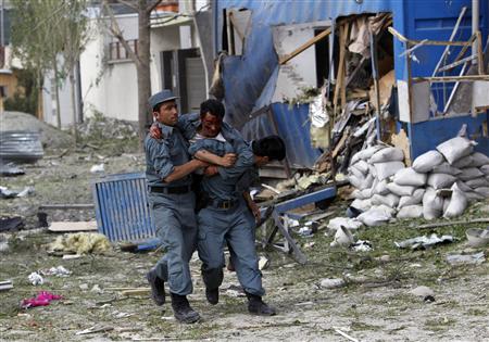 A wounded Afghan policeman (C) is helped away from the site of an explosion in Kabul May 24, 2013. REUTERS/Omar Sobhani