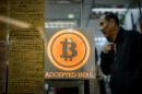 A man walks out of a shop displaying a bitcoin sign during the opening ceremony of the first bitcoin retail shop in Hong Kong on February 28, 2014