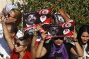 Tunisians hold posters of assasinated opposition politician Mohamed Brahmi during his funeral procession towards the nearby cemetery of El-Jellaz, where he is to be buried, in Tunis