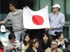 Fans of Japan's Misaki Doi hold a Japan flag as they watch her match against China's Jie Zheng at the All England Lawn Tennis Championships at Wimbledon, Thursday, June 23, 2011.(AP Photo/Sang Tan)