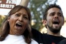 Maria Cruz, left, and Lincoln Statler chant as they join dozens who rally in front of U.S. Immigration and Customs Enforcement building, a day after a portion of Arizona's immigration law took effect, Wednesday, Sept. 19, 2012, in Phoenix. Civil rights activists contend will lead to systematic racial profiling, as the protesters chanted 
