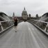 A man runs along an almost deserted Millennium Bridge, with St Paul's Cathedral in the background centre, in central London, Wednesday, Aug. 1, 2012. People are heeding government advice and staying away from central London during the London 2012 Olympics. (AP Photo/Sang Tan)