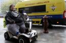 Kevin Chenais sits in his mobility scooter in front of an ambulance at St Pancras in London, Wednesday, Nov. 20, 2013. Kevin, who suffers from a medical condition will travel by ambulance and ferry back to France. (AP Photo/Kirsty Wigglesworth)