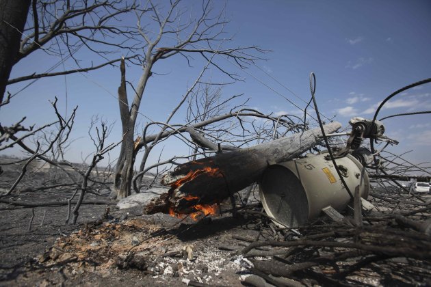 A power line pole and transformer smolder in an area destroyed by a wildfire at Possum Kingdom Lake, Texas, Wednesday, Aug. 31, 2011. The wildfire that swept through the neighborhood on Tuesday, one o