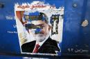 The remnants of a poster of ousted Egyptian President Mohamed Mursi are seen at a petrol station in Cairo