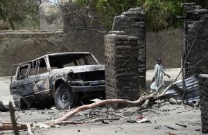 A boy walks past a burnt house and car on April 6, &hellip;