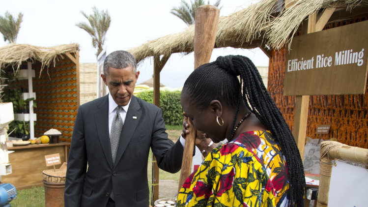 Oumou Gadio, a local farmer, shows U.S. President Barack Obama an old technique for rice milling during a food security expo tour on Friday, June 28, 2013, in Dakar, Senegal. Obama met with farmers, innovators, and entrepreneurs whose new methods and technologies are improving the lives of smallholder farmers throughout West Africa. (AP Photo/Evan Vucci)