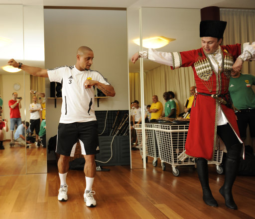 In this image made available in Moscow, Friday July 15, 2011, Brazilian Roberto Carlos of Anzhi, left, a Russian soccer club based in Makhachkala, the capital of the Republic of Dagestan, which competes in the Russian Premier League, learns to dance lezginka, a national dance of many people of the Caucasus Mountains with a Dagestan dancer after a training session at a hotel in Bad Waltersdorf, Austria, Wednesday July 13, 2011.(AP Photo/Sergei Rasulov Jr.)
