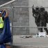 A worker puts up tarps on a temporary fence around the statue of the late Penn State football coach Joe Paterno before removing the statue outside Beaver Stadium in State College Pennsylvania