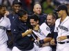 Seattle Mariners' Luis Rodriguez, center, is put into a playful headlock by Felix Hernandez as other teammates cheer Rodriguez following his game-winning home run against the New York Yankees  in the 12th inning of a baseball game Wednesday, Sept. 14, 2011, in Seattle. The Mariners won 2-1. (AP Photo/Elaine Thompson)