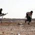 Anti-Gaddafi fighters take cover from sniper fire at a checkpoint north of Bani Walid
