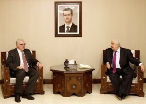 Syrian Foreign Minister Walid Muallem (right) holds …