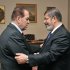 In this photo released by Middle East News Agency, the Egyptian official news agency, caretaker Prime Minister Kamal el-Ganzouri, left, shakes hands with newly elected President Mohammed Morsi in Cairo, Egypt, Monday, June 25, 2012. Morsi met with the military-backed Prime Minister el-Ganzouri, who resigned Monday and was asked to head a caretaker government until Morsi nominates a new one. The election of an Islamist president in Egypt is turning longstanding U.S. policy in the Mideast inside out. The Obama administration is relieved that the candidate who represents three decades of close partnership with the United States was beaten by an Islamic fundamentalist. (AP Photo/Middle East News Agency, HO)