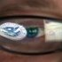 FILE - This Sept. 30, 2011 file photo shows a reflection of the Department of Homeland Security logo in the eyeglasses of a cybersecurity analyst at the watch and warning center of the Department of Homeland Security's secretive cyber defense facility in Idaho Falls, Idaho. The center is tasked with protecting the nation’s power, water and chemical plants, electrical grid and other facilities from cyber attacks. (AP Photo/Mark J. Terrill, File)