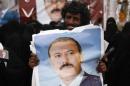 A man holds a poster of Yemen's former President Ali Abdullah Saleh outside al-Saleh mosque after weekly Friday prayers in Sanaa