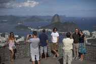 Varios turistas posan para una foto frente al cerro Pan de Azúcar en Río de Janeiro, Brasil, el martes 14 de febrero de 2012. (Foto AP/Felipe Dana)
