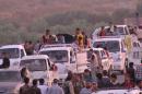 This image made from video taken on Sunday, Aug. 3, 2014 shows Iraqis people from the Yazidi community arriving in Irbil in northern Iraq after Islamic militants attacked the towns of Sinjar and Zunmar. Around 40 thousand people crossed the bridge of Shela in Fishkhabur into the Northern Kurdish Region of Iraq, after being given an ultimatum by Islamic militants to either convert to Islam, pay a security tax, leave their homes, or die. (AP Photo via AP video)