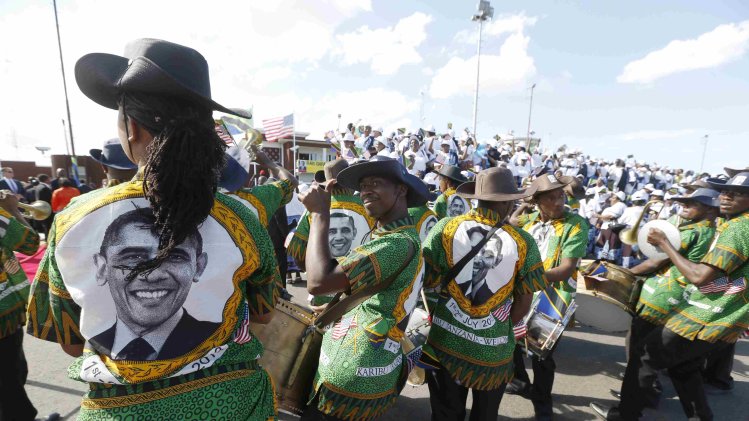 A Tanzanian band wears shirts featuring images of U.S. President Obama during an official arrival ceremony at Julius Nyerere Airport in Dar es Salaam