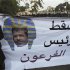 Anti-Mursi protesters point to a banner during a protest in front of the presidential palace in Cairo